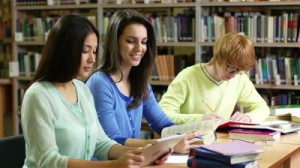 stock-footage-young-people-studying-at-the-library-girl-using-a-tablet-pc-instead-of-a-book