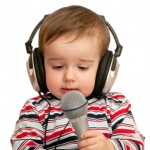 Given a speech toddler with headphones and microphone, closeup